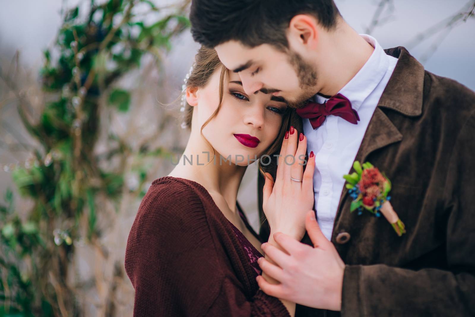 groom in a brown and bride in burgundy in the mountains Carpathians