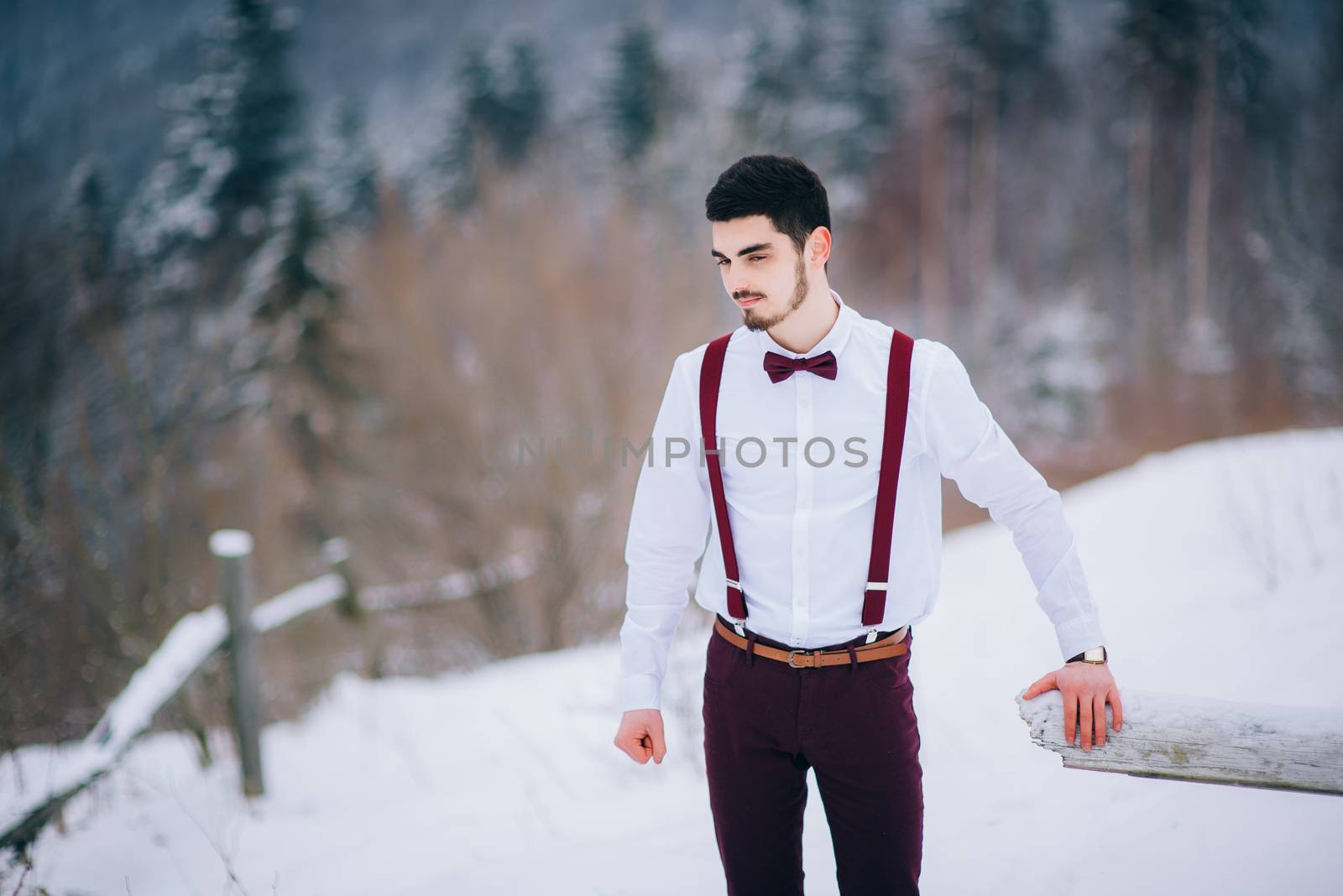 groom in a brown and bride in burgundy in the mountains Carpathians