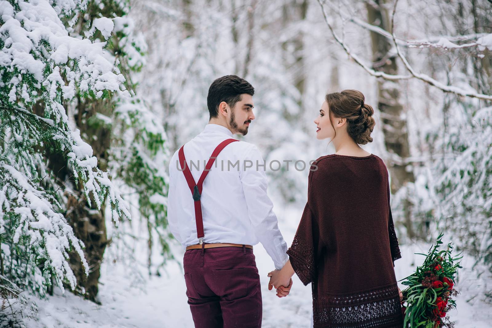 groom in a brown and bride in burgundy in the mountains Carpathians