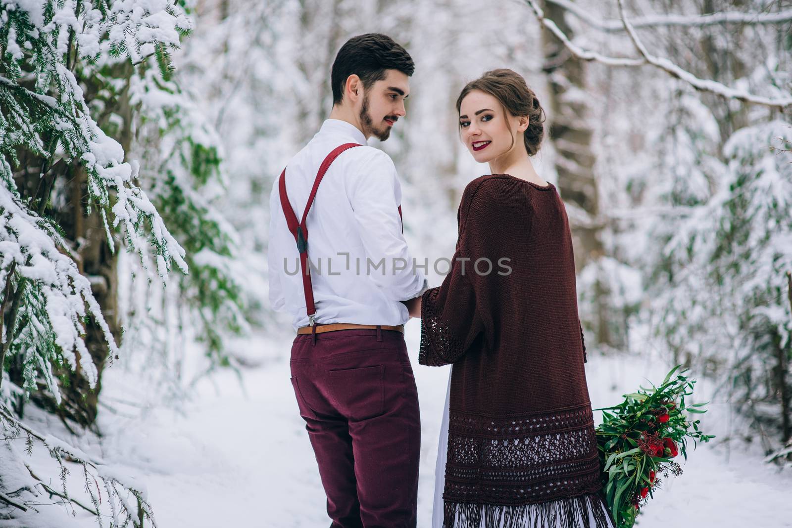 groom in a brown and bride in burgundy in the mountains Carpathians