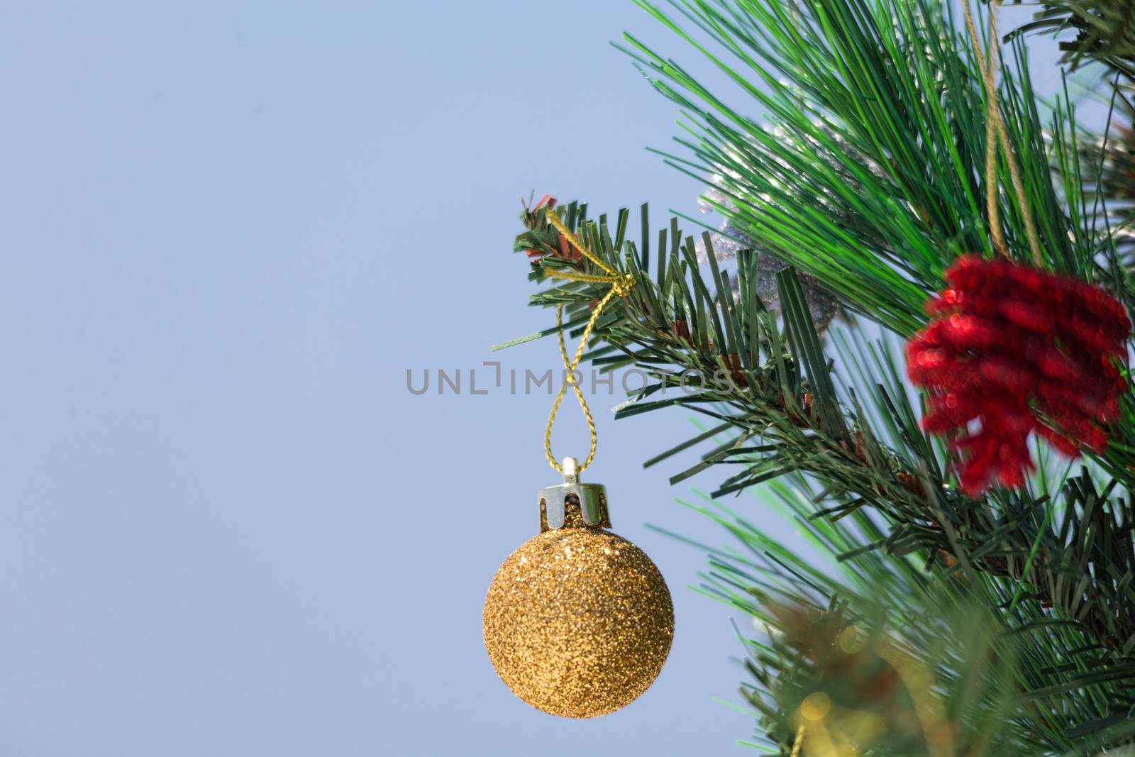 A Christmas tree is decorated with baubles.  A closeup with shallof dof and copy space.