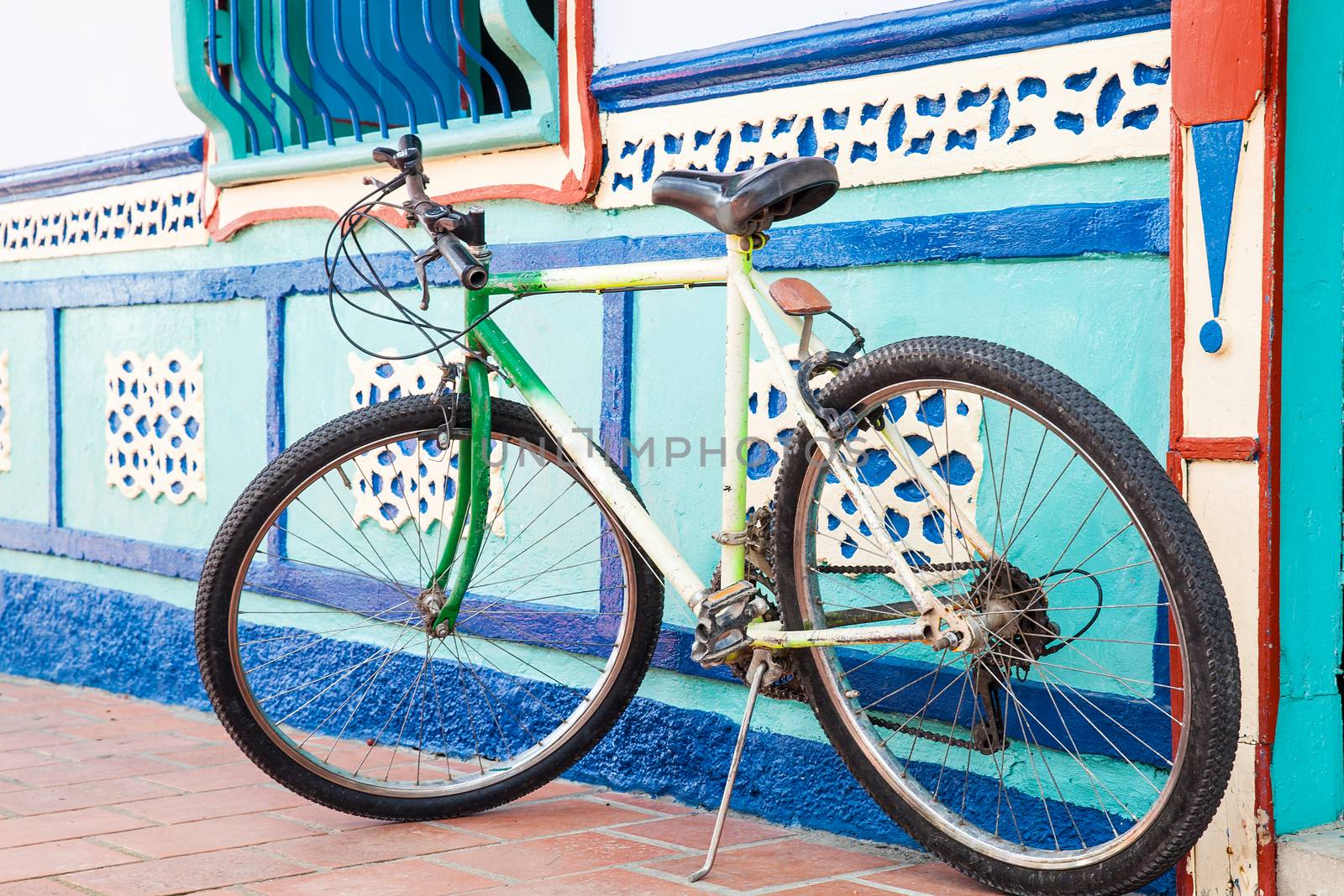 Bicycle next to a beautiful blue and white house at Guatape, Colombia