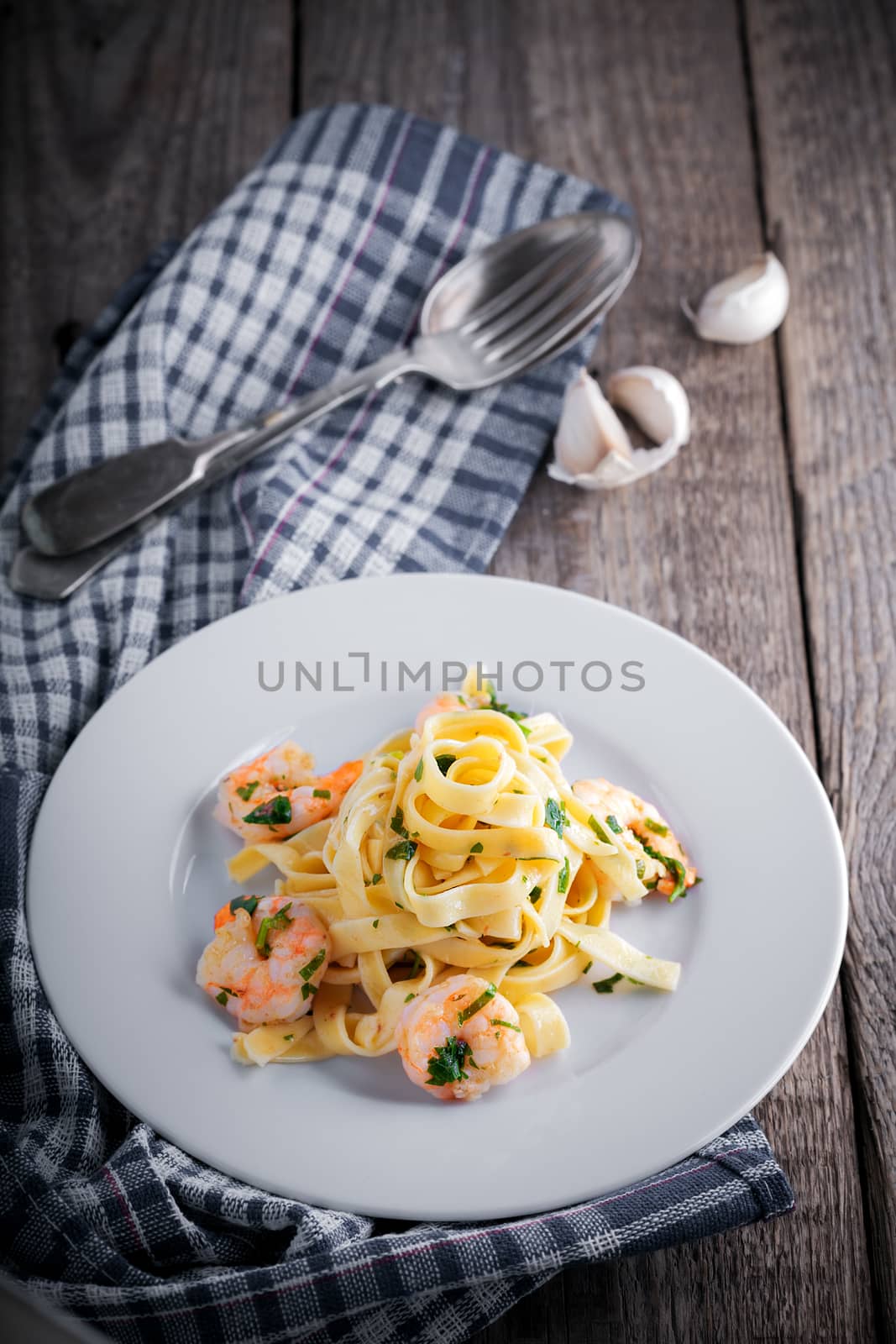 Tagliatelle with shrimps garlic on a wooden surface