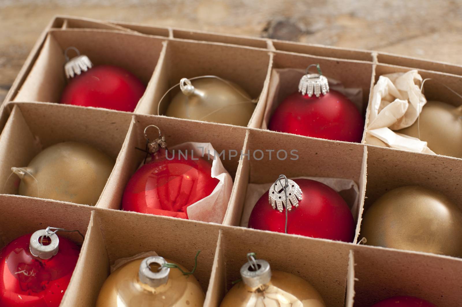 Cardboard box of colorful Christmas decorations with red and gold baubles or balls for the Xmas tree to celebrate the festive holiday season