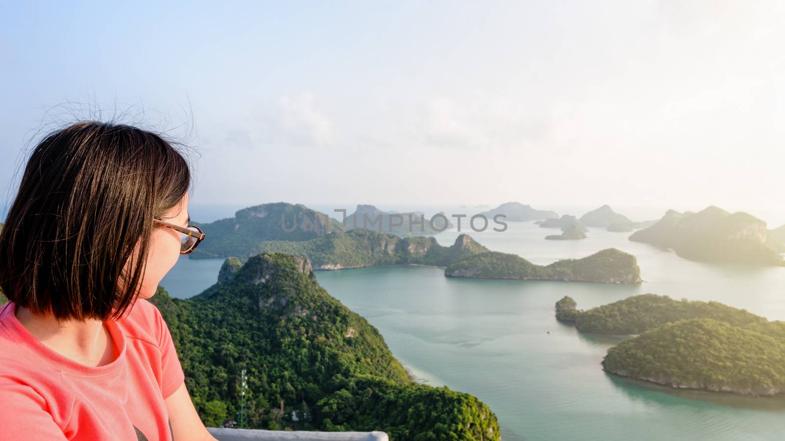 Woman tourist on peak view point of Ko Wua Ta Lap island looking beautiful nature landscape during sunrise over the sea in Mu Ko Ang Thong National Park, Surat Thani, Thailand, 16:9 widescreen