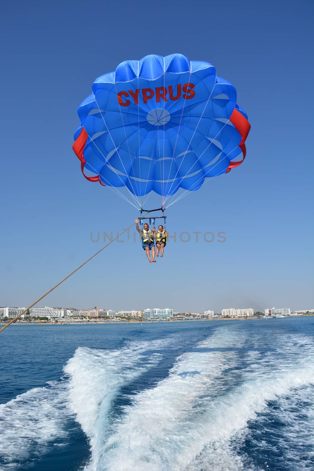 Flight on a parachute over the water high in the sky