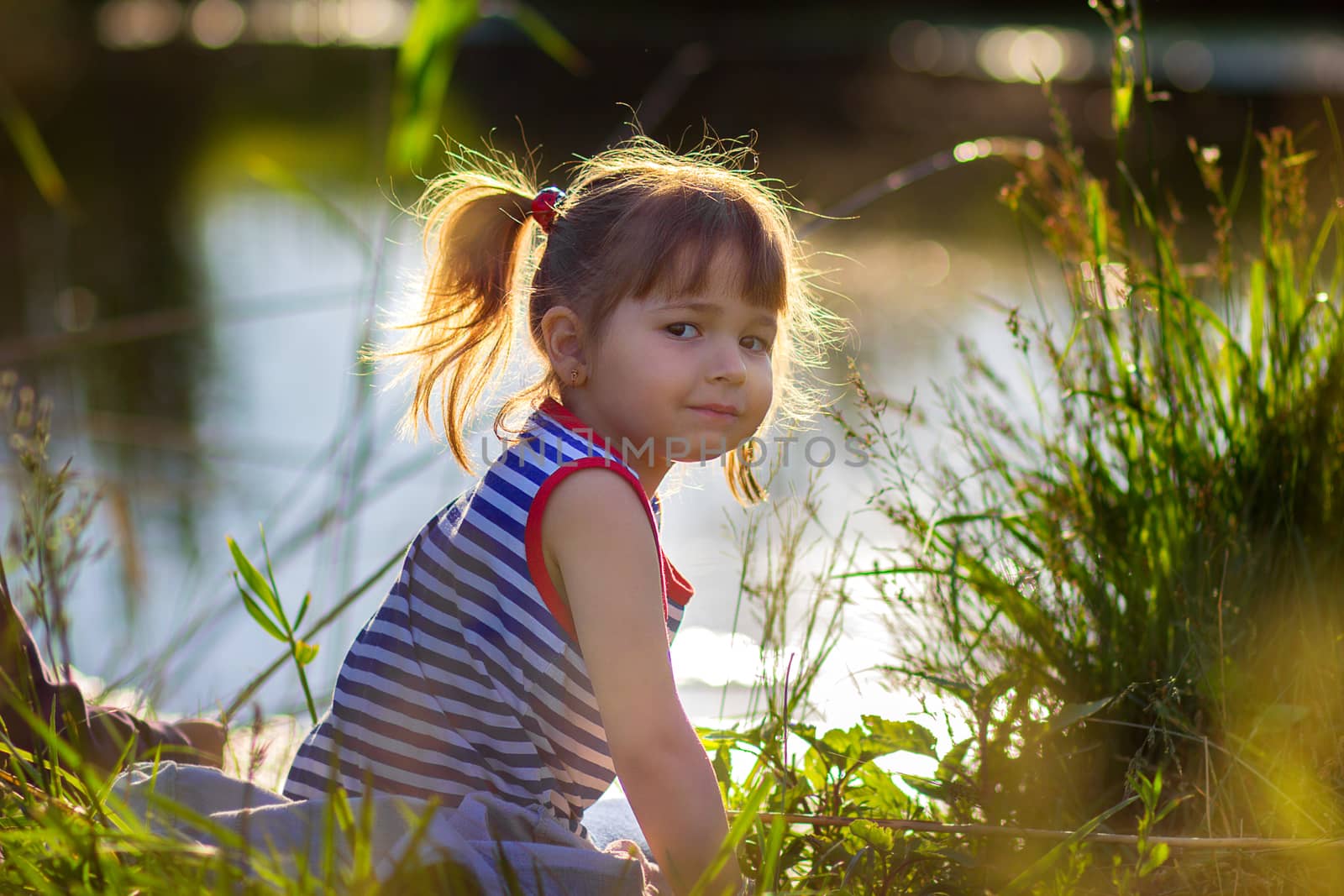 the girl in a striped undershirt near the lake