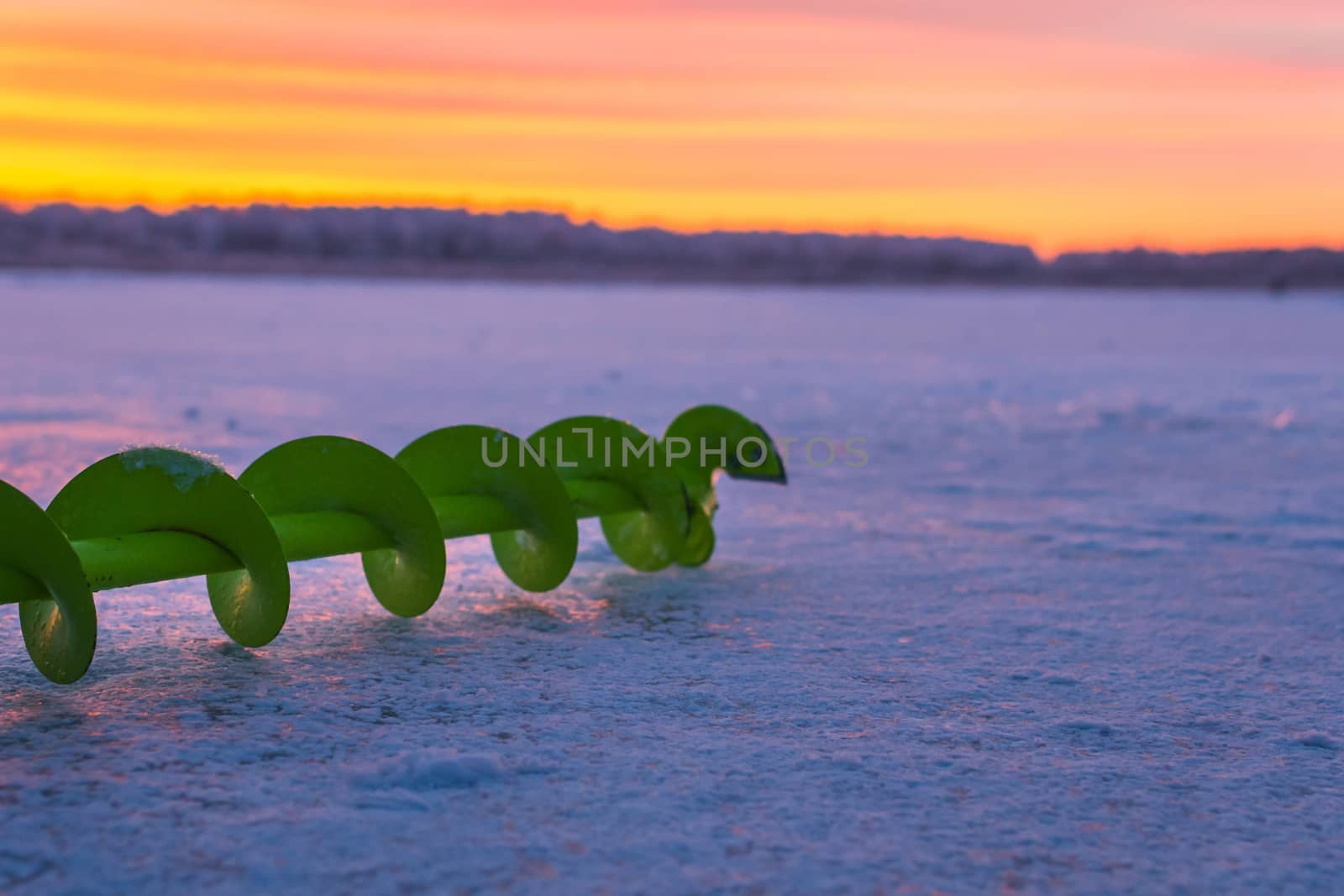 Fishing ice auger at dawn fishing drill ice beautiful sky