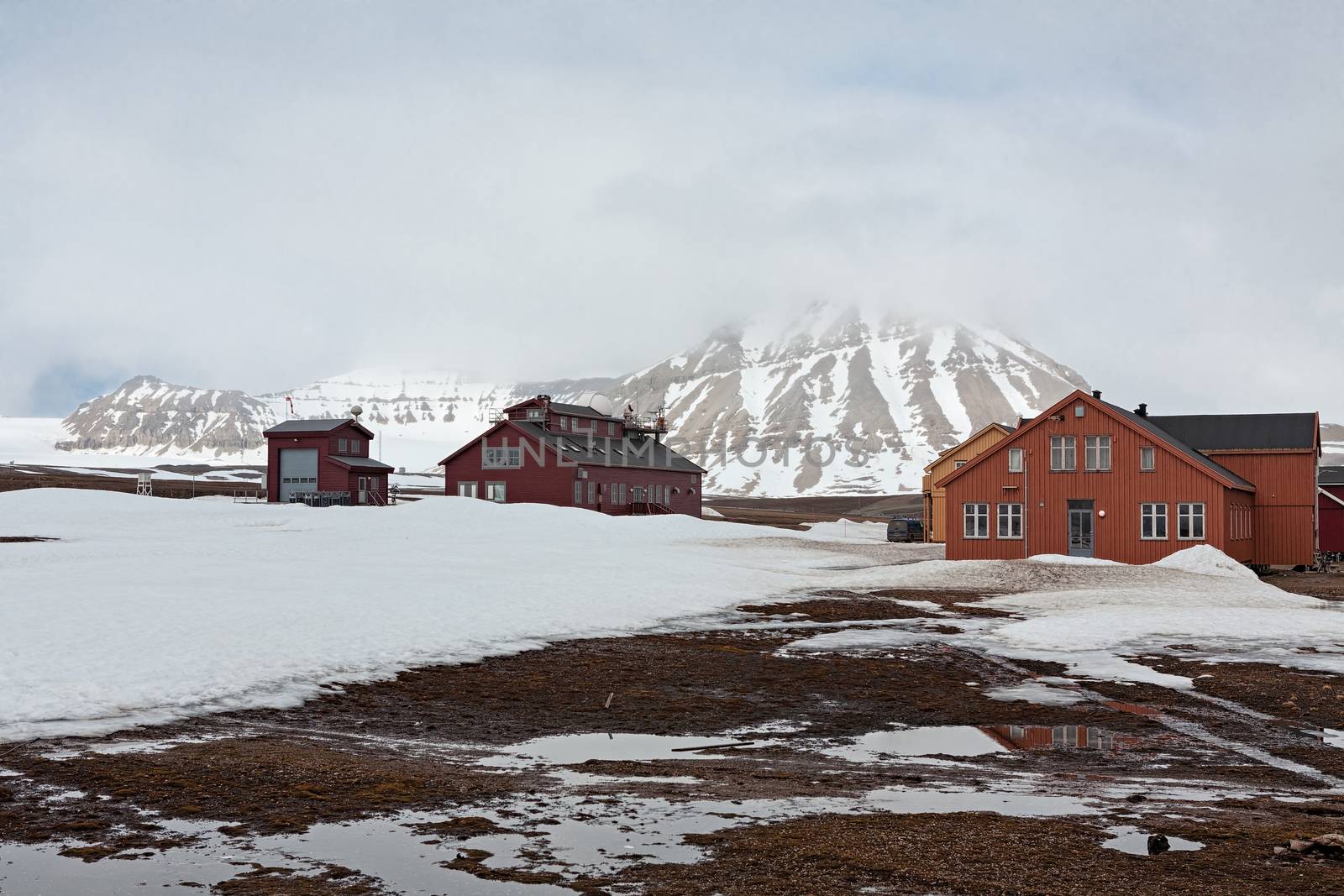 Wooden houses and meteorological station in Ny Alesund in a foggy day, Svalbard islands, Norway