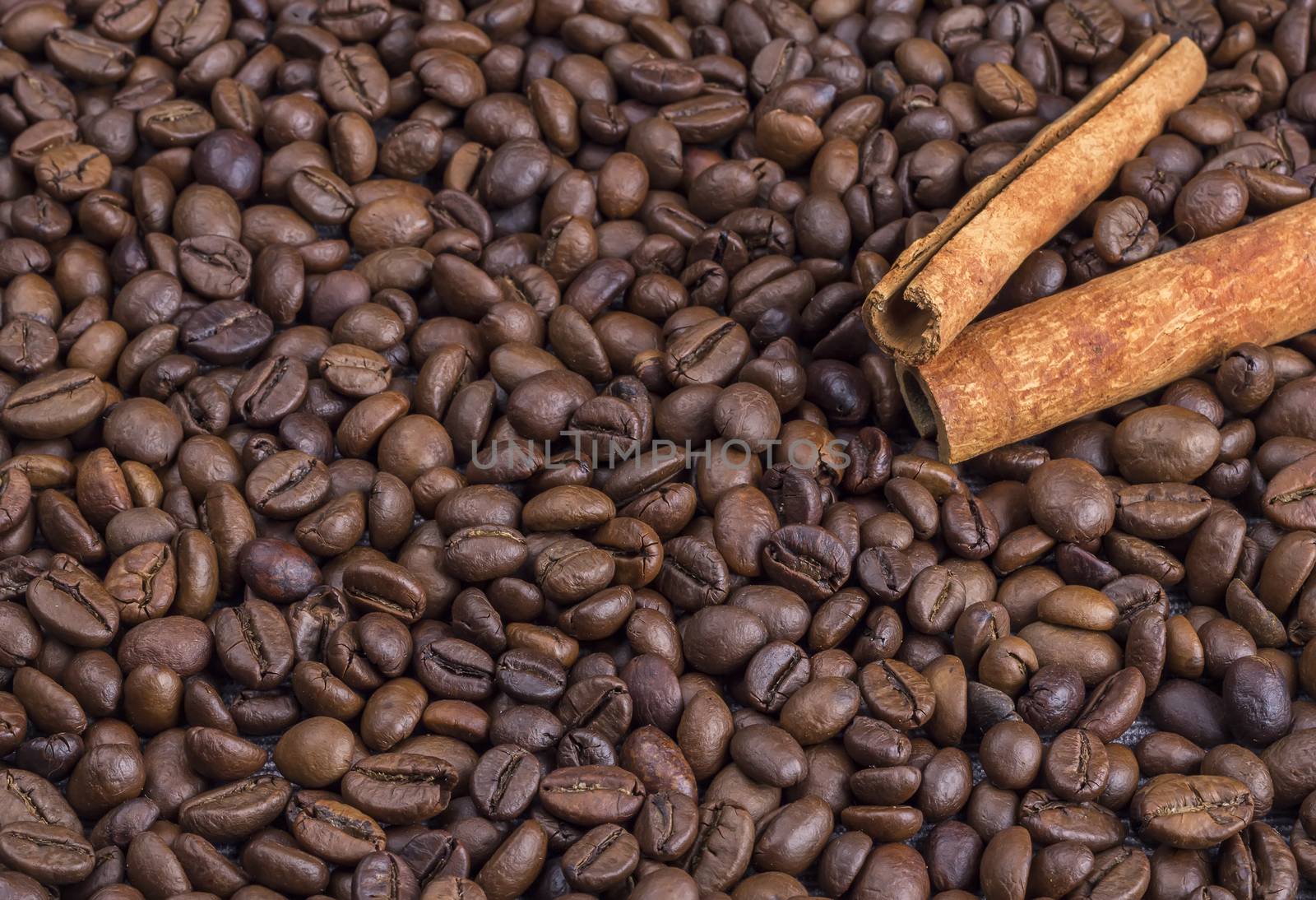 Cinnamon on the coffee beans. A lot of coffee beans background.