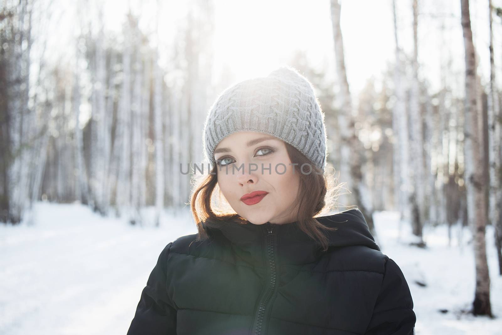 Beautiful young girl in a white winter forest.