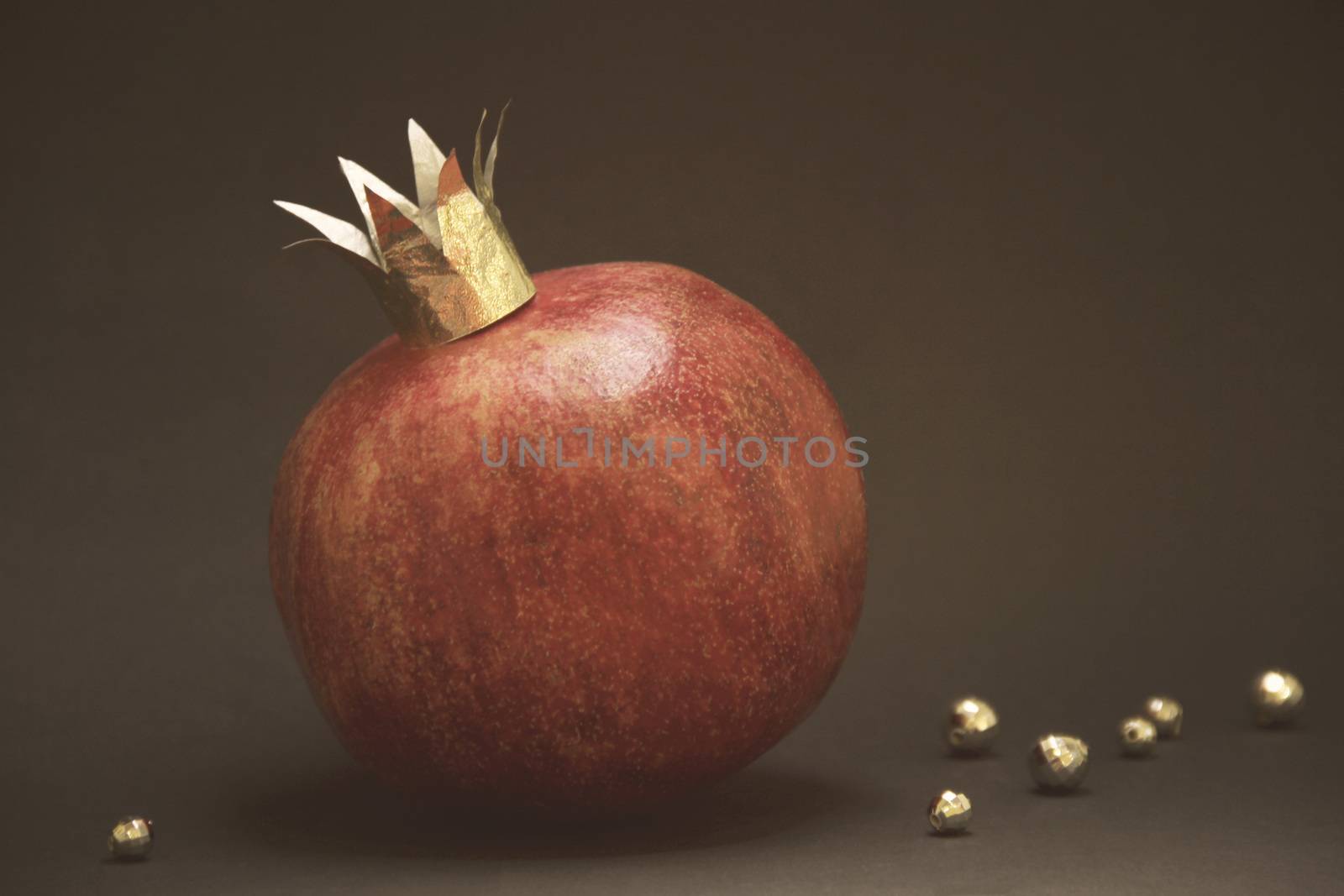 large red pomegranatre or garnet with a golden crown on a vintage background. photo