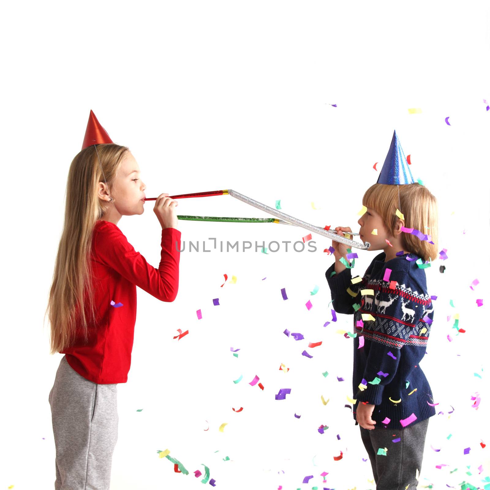 Children blowing party trumpets by ALotOfPeople