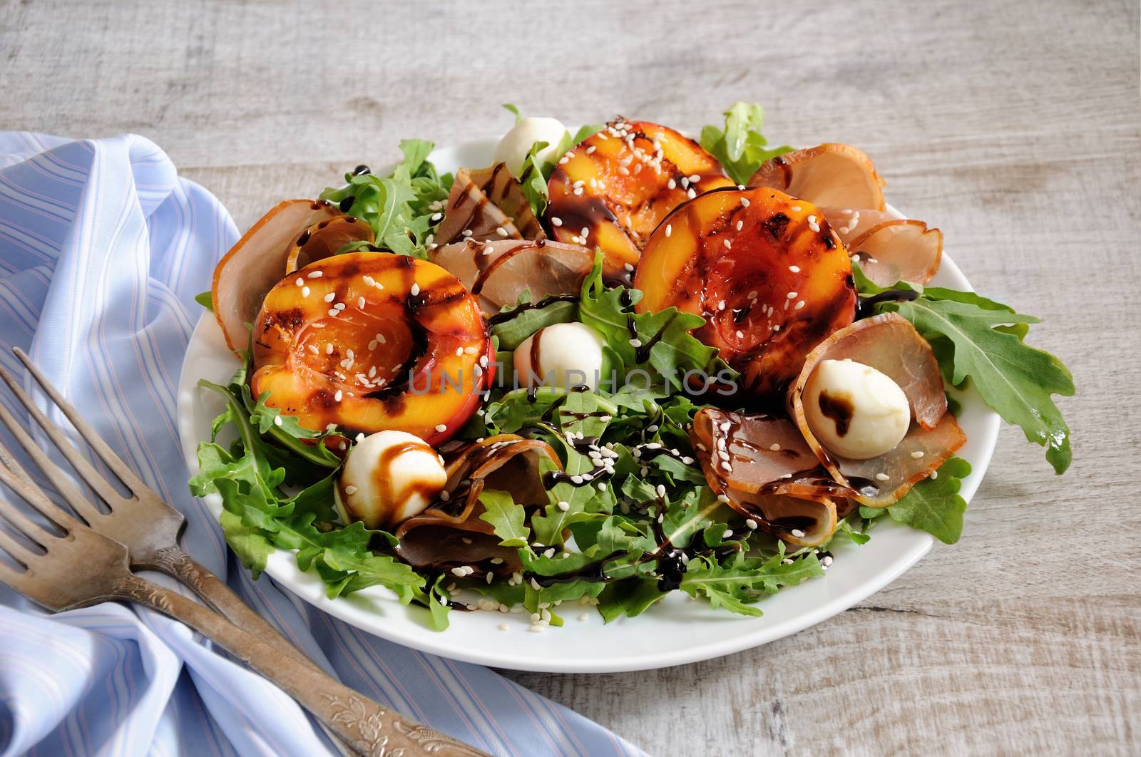 Salad with dried ham, grilled nectarine, mozzarella and arugula