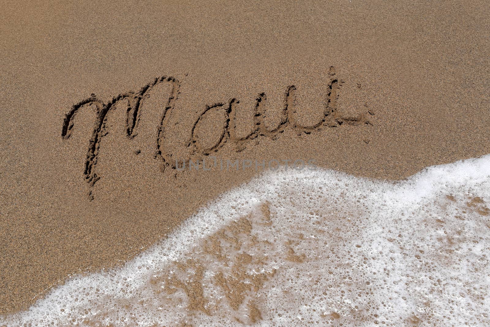 The Word Maui Written Into the Sand With Sea Foam