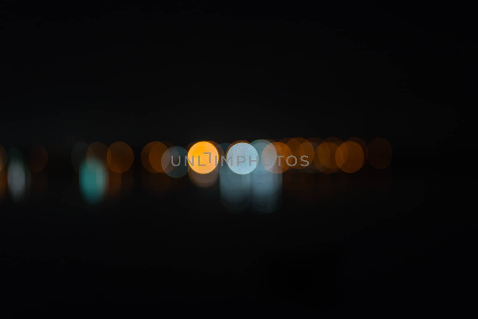 abstract defocused  city lights in distance on dark night sky background by brians101