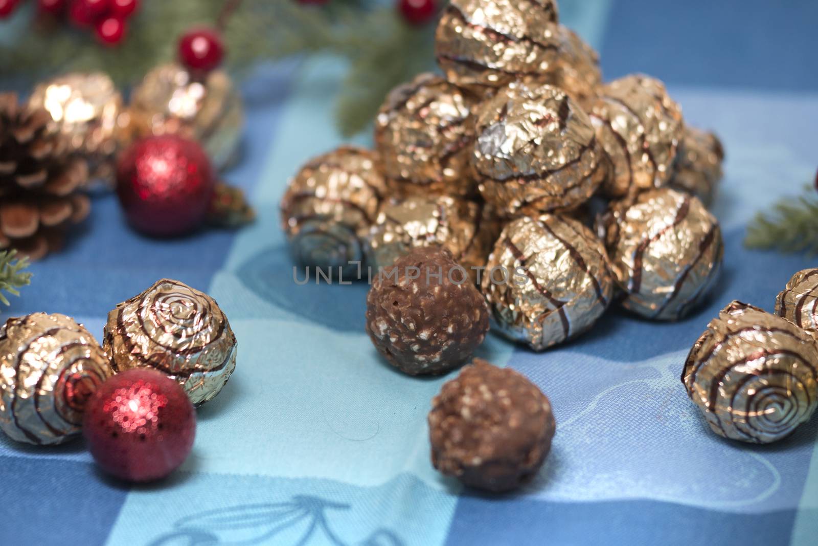 Pile of sweet round chocolate candies for christmas celebrations on a table cloth.