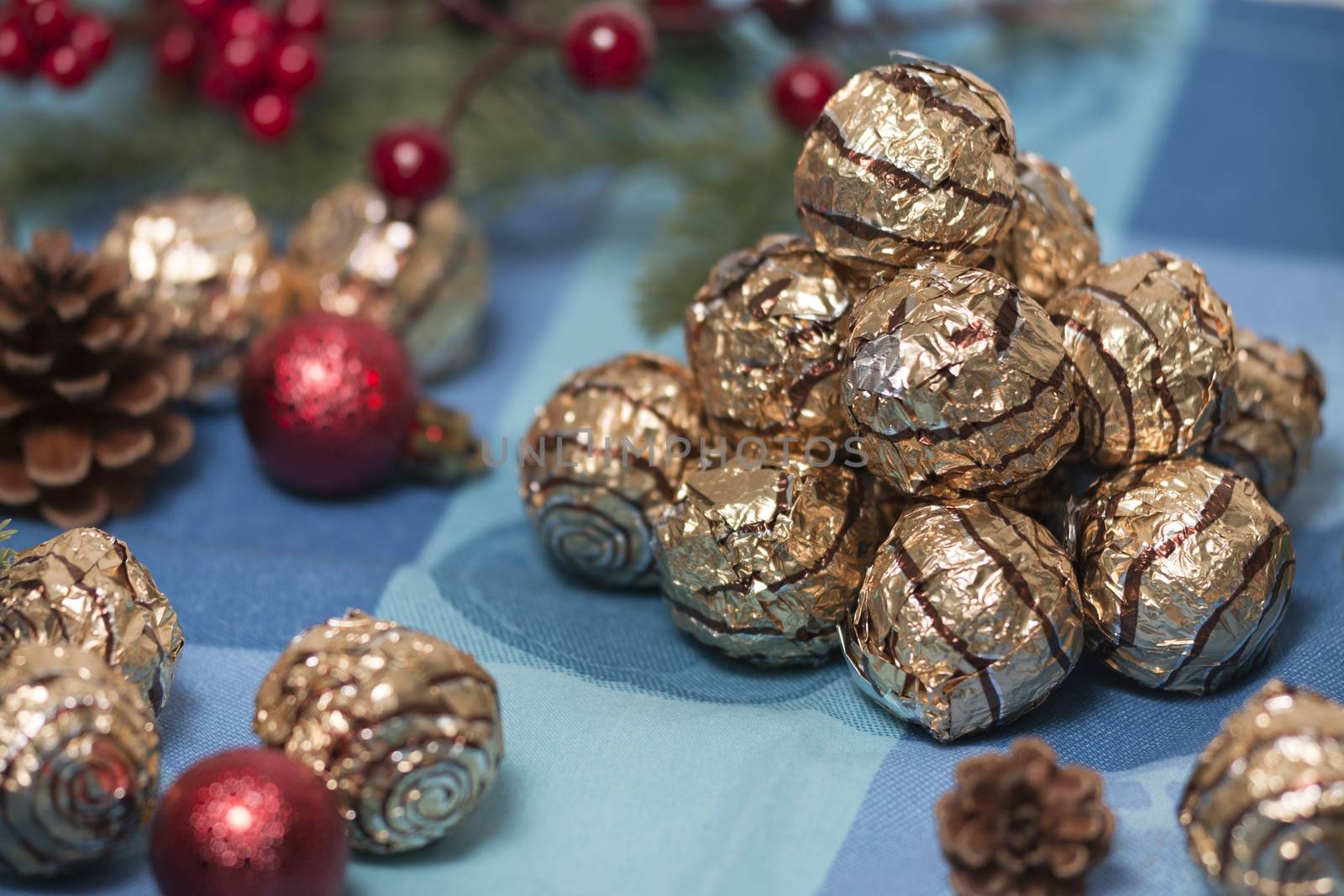 Pile of sweet round chocolate candies for christmas celebrations on a table cloth.