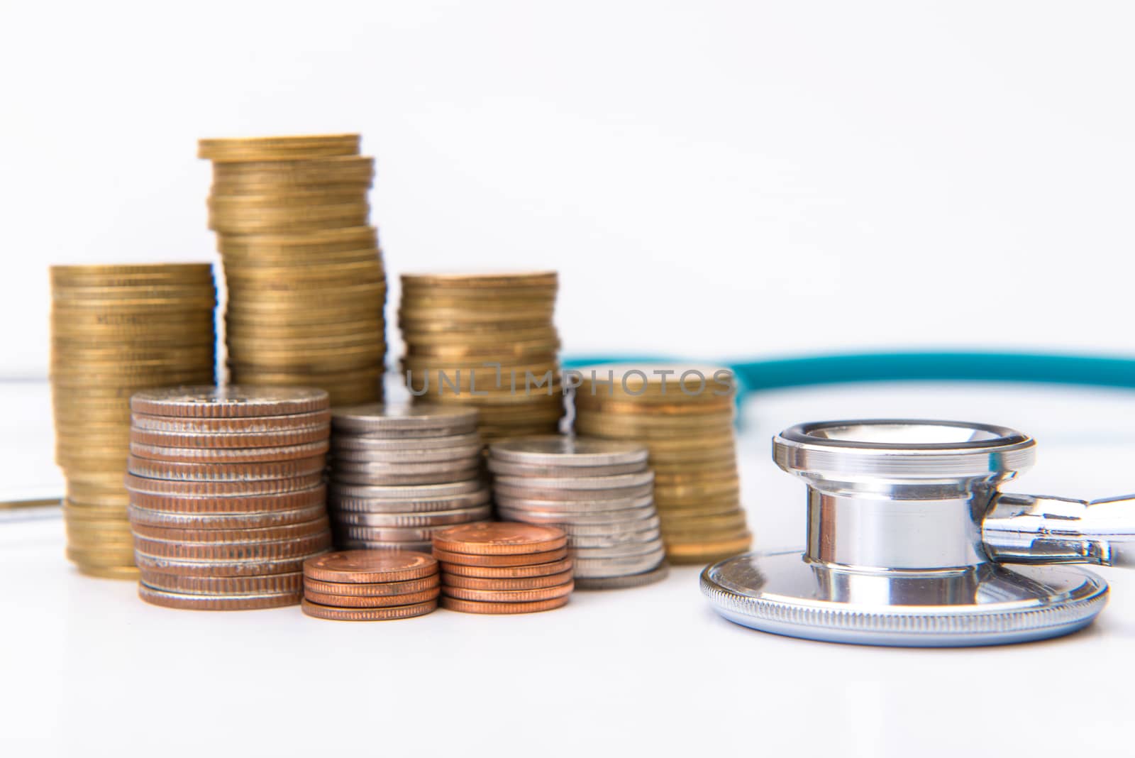 coin stack growing business with medical instruments stethoscope, Saving money concept.