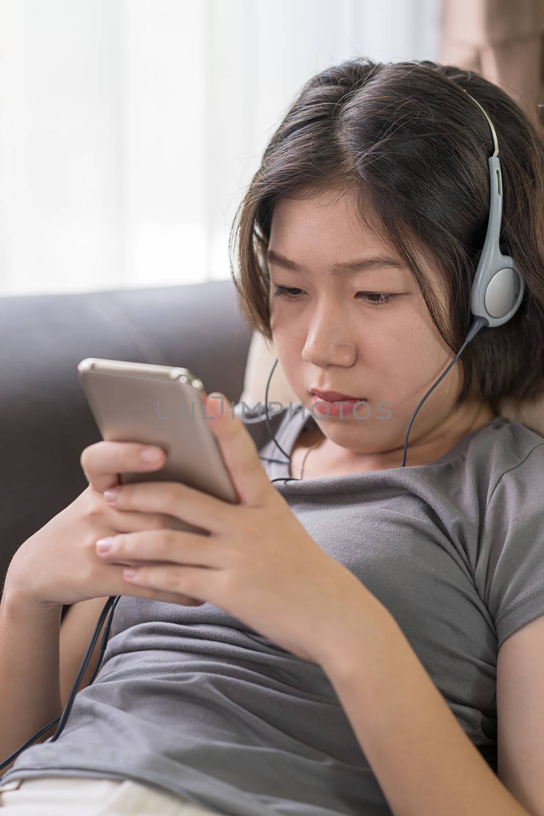 Asian woman listening music from mobile phone by stoonn