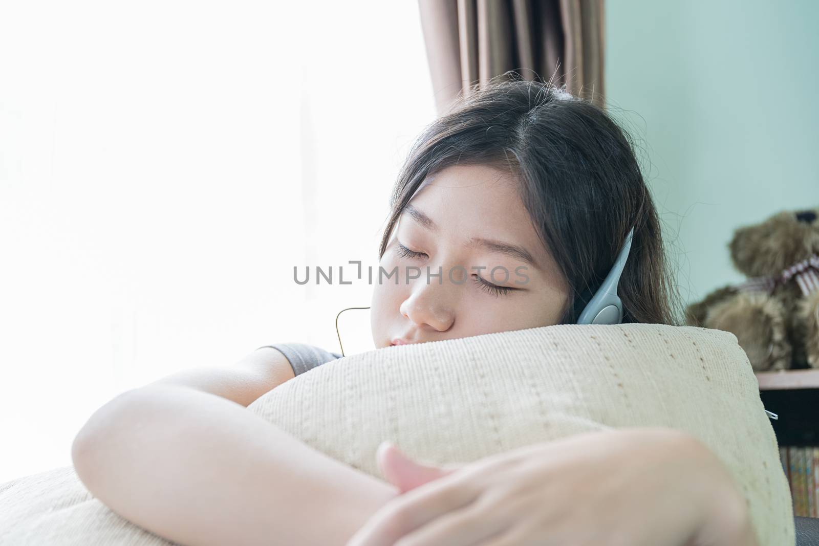 Close up young asian woman short hair listening music on the couch at home