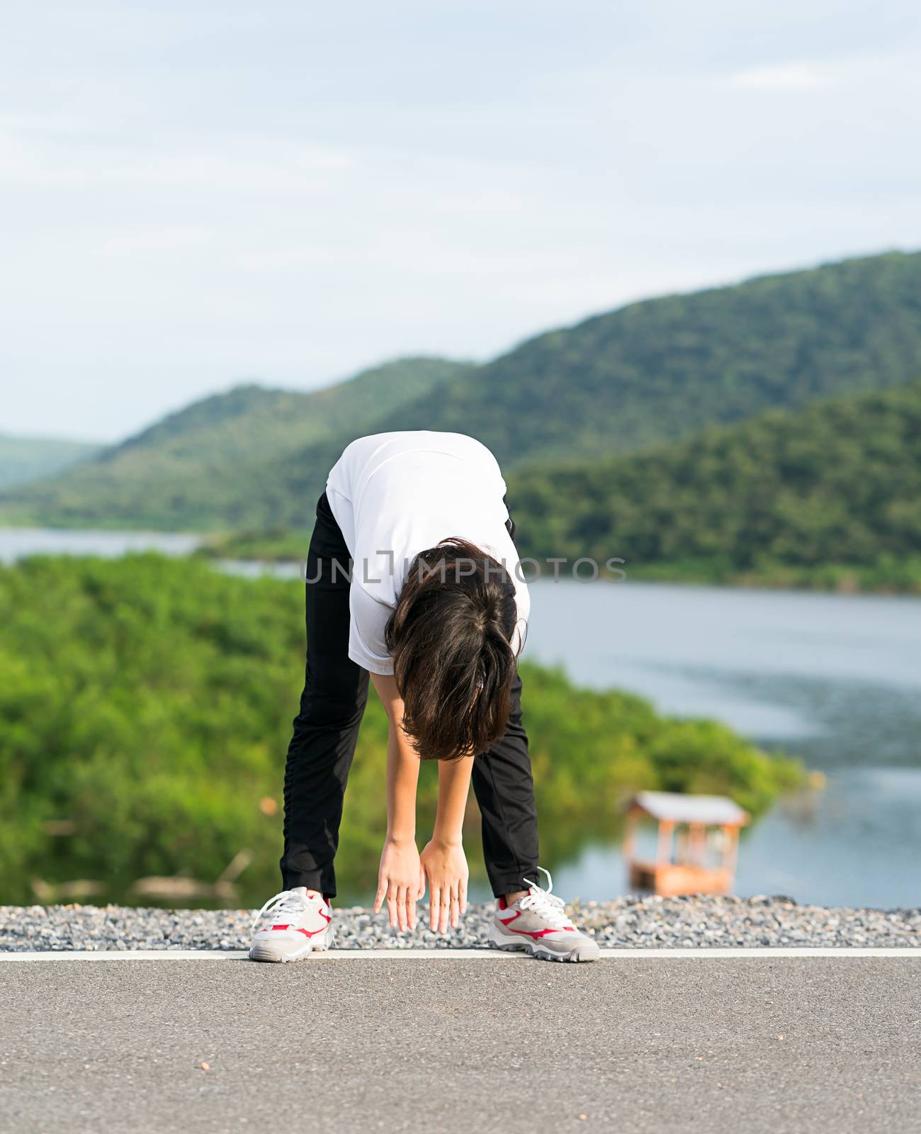 Woman doing exercising and warm up outdoor by stoonn