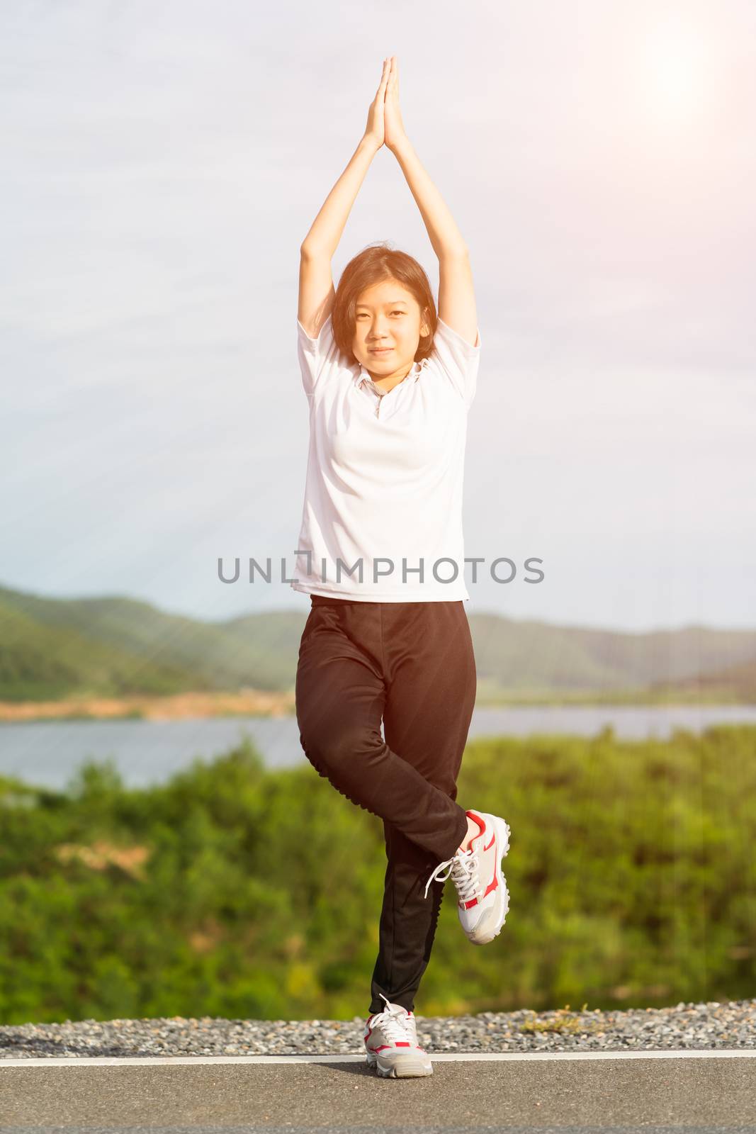 Fitness and lifestyle concept - Young asian woman short hair doing exercising outdoor and warm up preparing for jogging