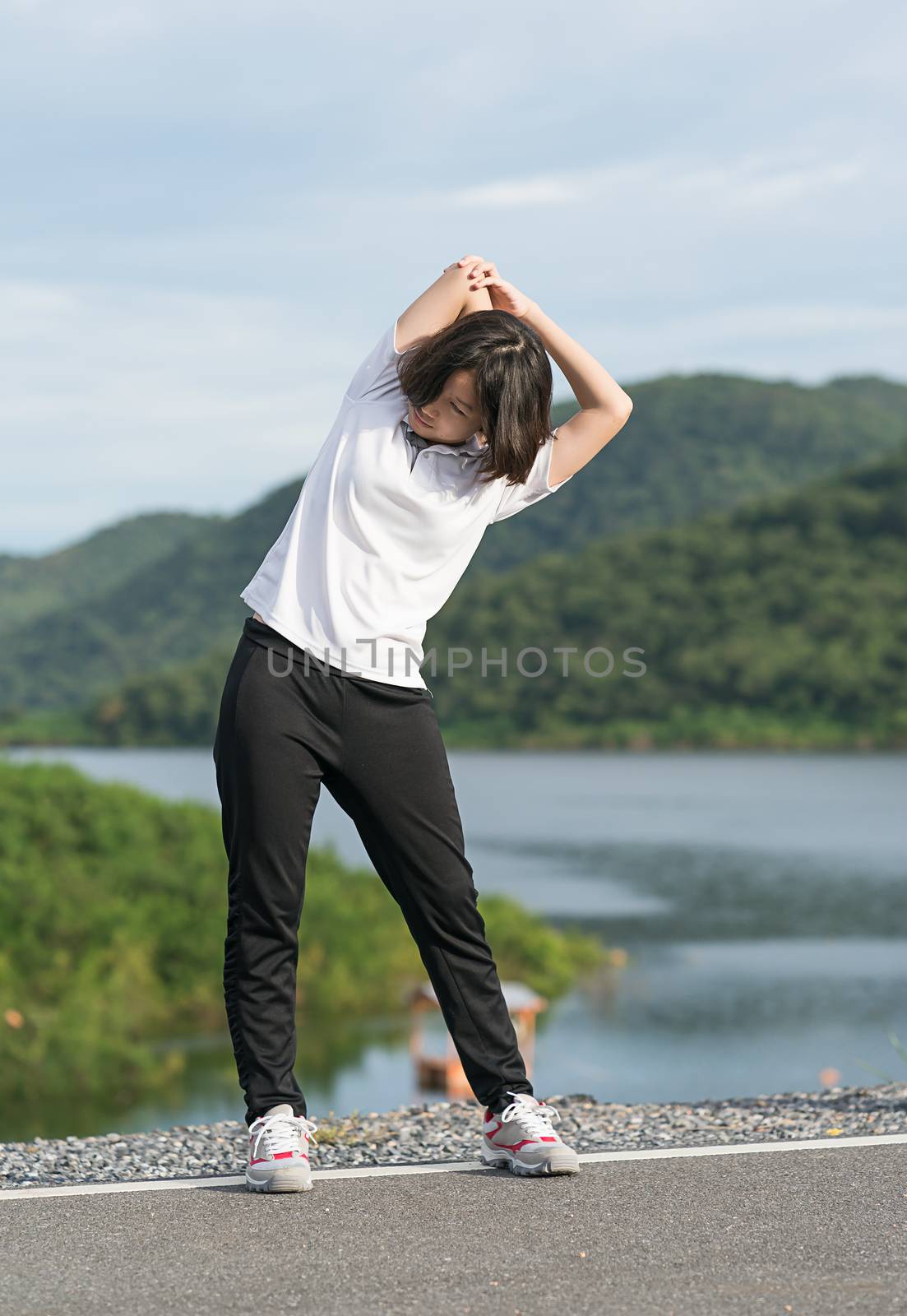 Woman short hair doing exercising outdoor by stoonn