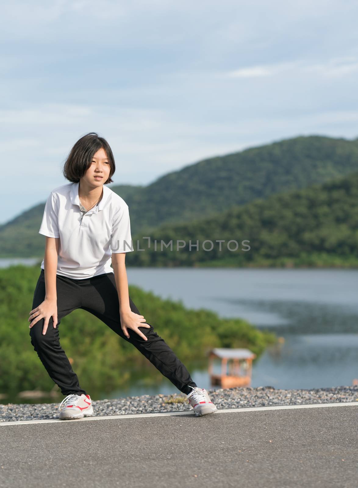 Woman short hair doing exercising outdoor by stoonn