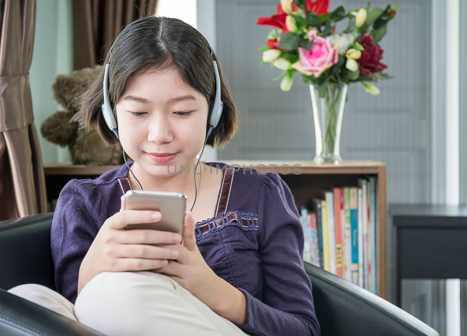 Close up beautiful young asian woman short hair listening music in living room at home