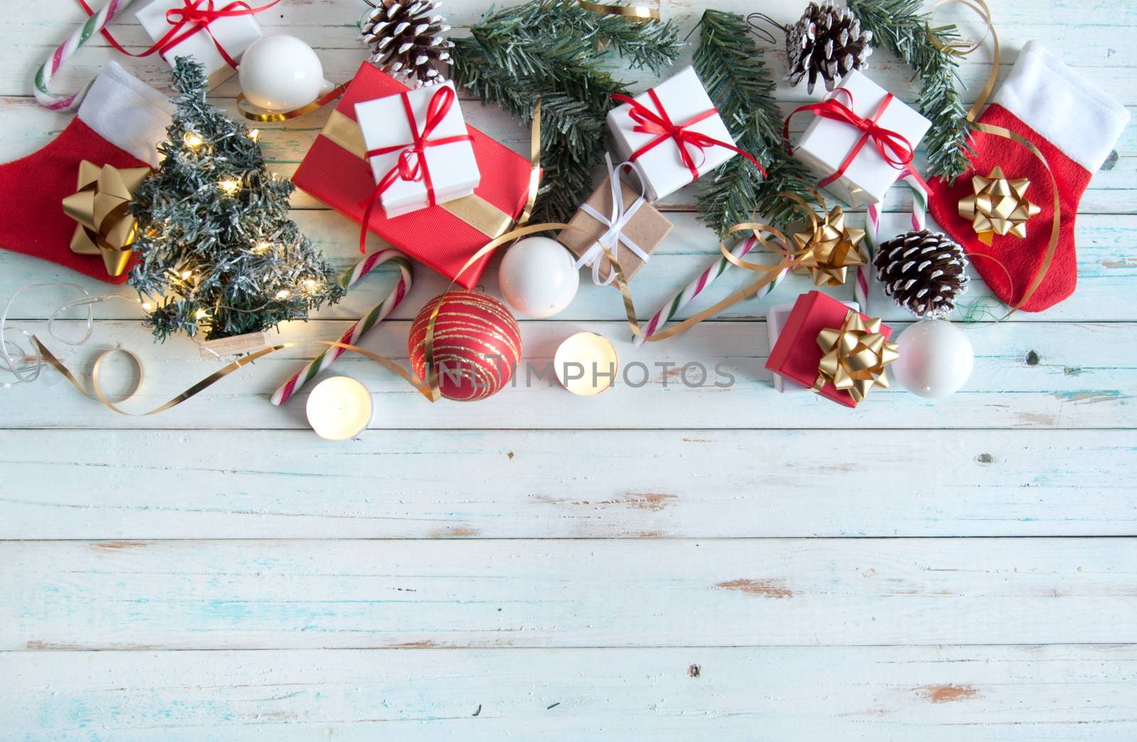 Christmas gifts and decorations with candles on a wooden background