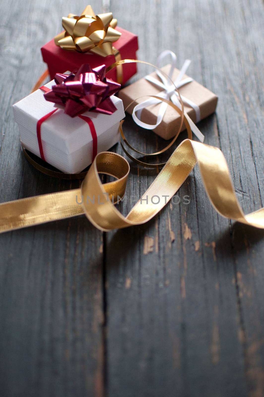 Christmas gift boxes wrapped with ribbon over a wooden background