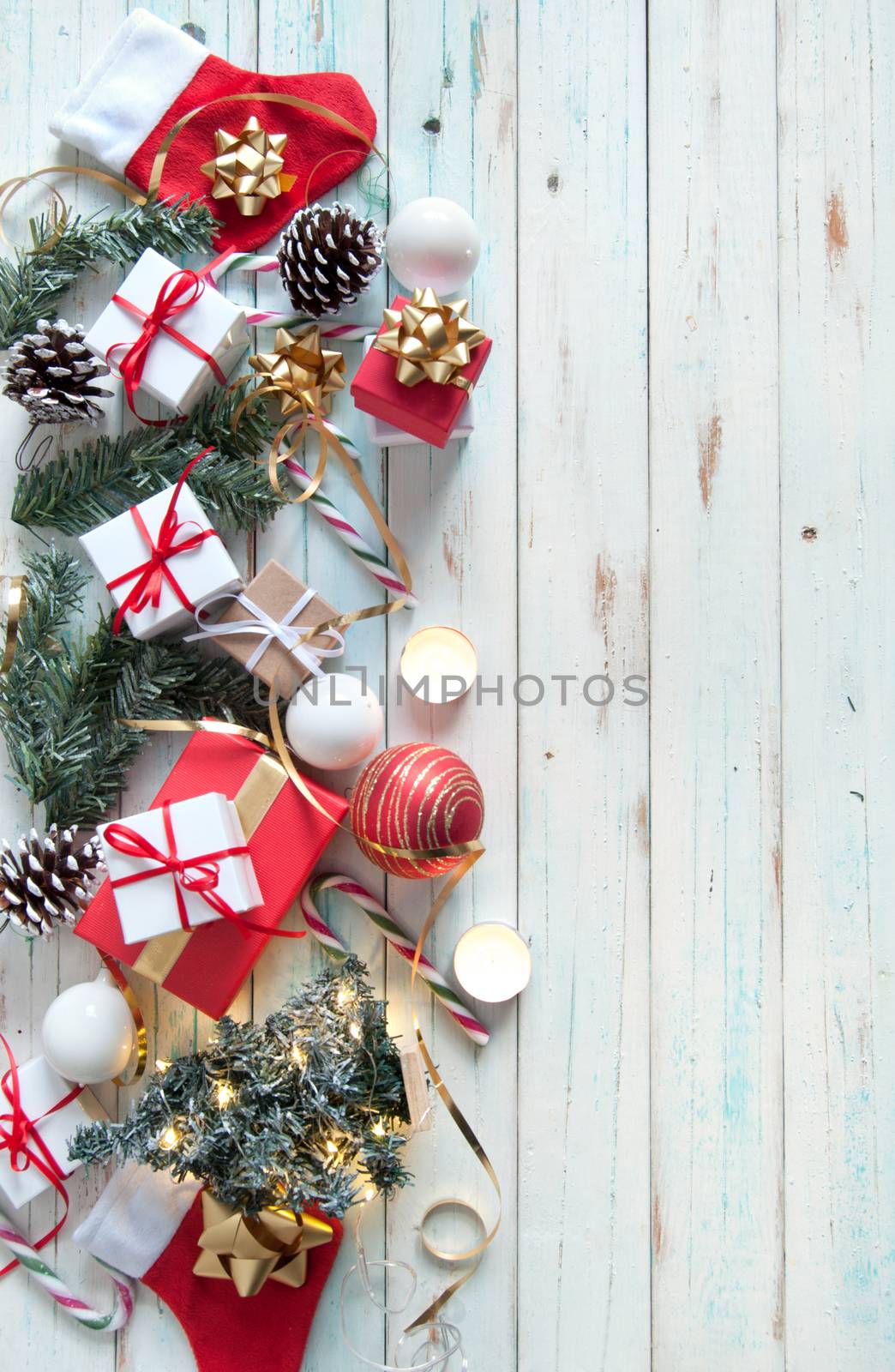 Christmas gifts and decorations with candles on a wooden background