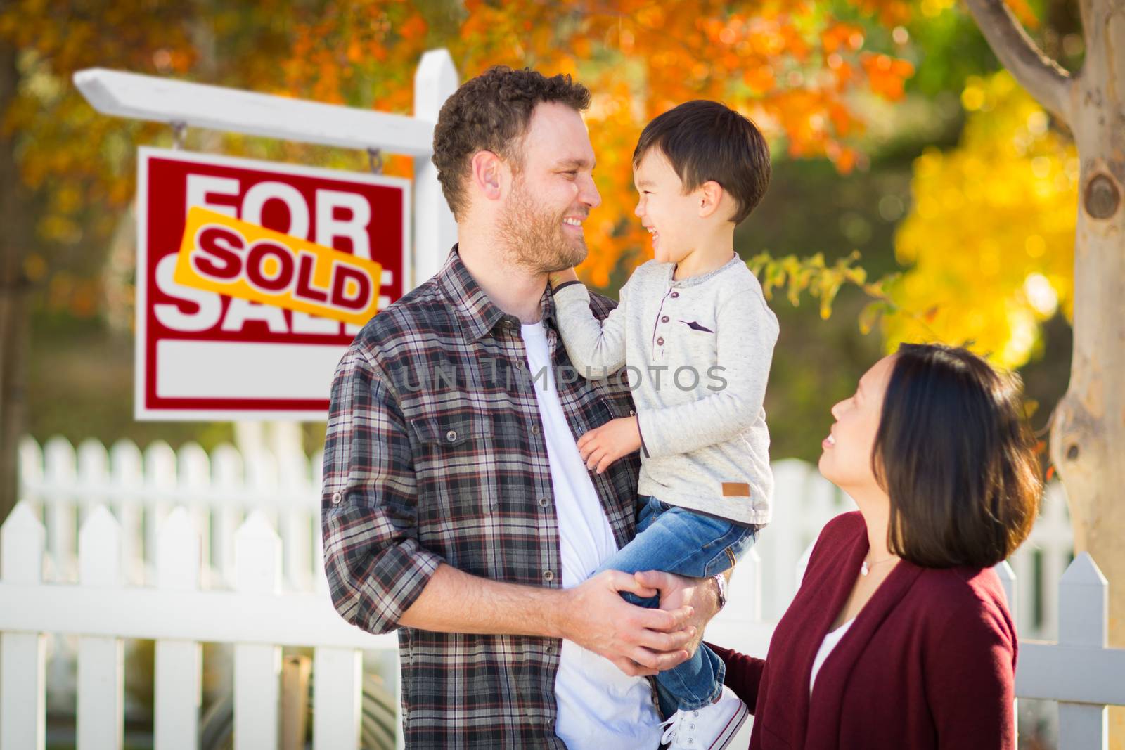 Mixed Race Chinese and Caucasian Parents and Child In Front of Fence and Sold For Sale Real Estate Sign. by Feverpitched