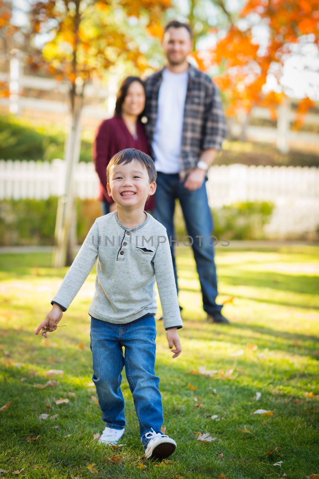 Outdoor Portrait of Happy Mixed Race Chinese and Caucasian Parents and Child. by Feverpitched
