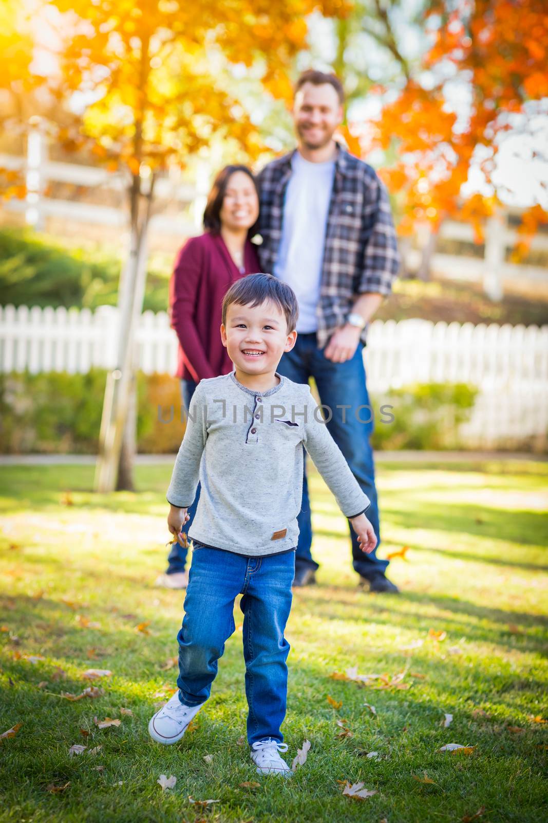 Outdoor Portrait of Happy Mixed Race Chinese and Caucasian Parents and Child.