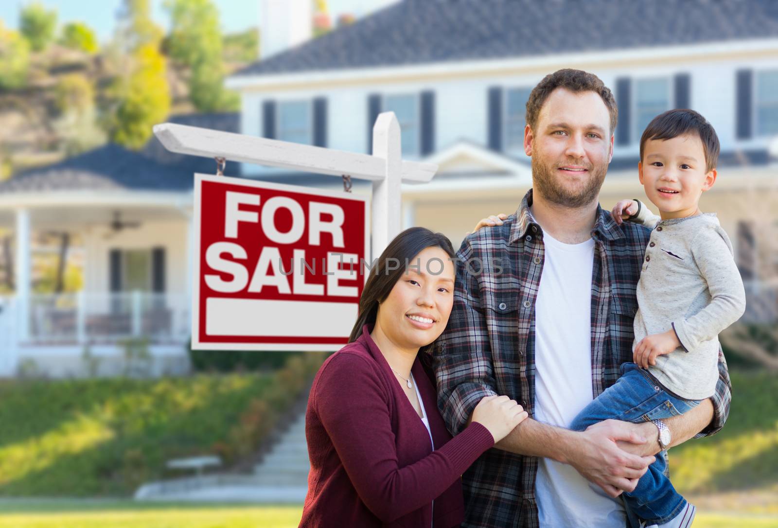 Mixed Race Chinese and Caucasian Parents and Child In Front of House and For Sale Real Estate Sign.
