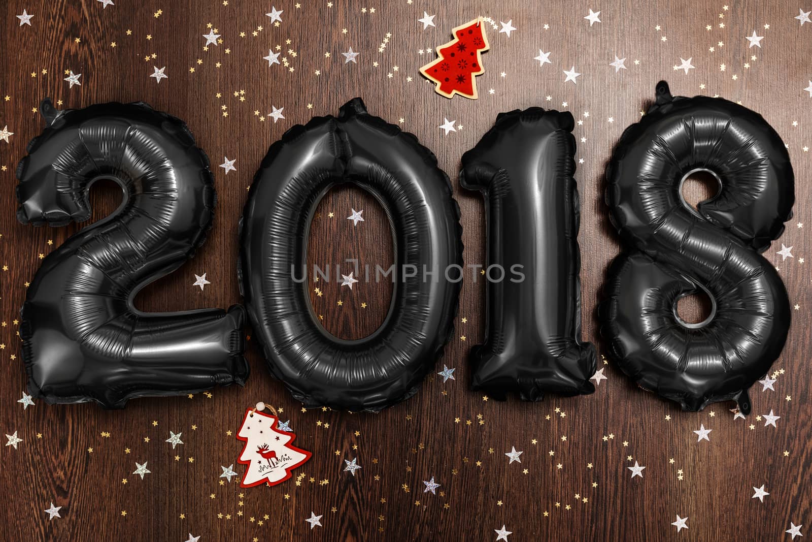 Bright black balloons figures 2018, New Year Balloons with glitter stars on dark wood table background. Christmas and new year celebration