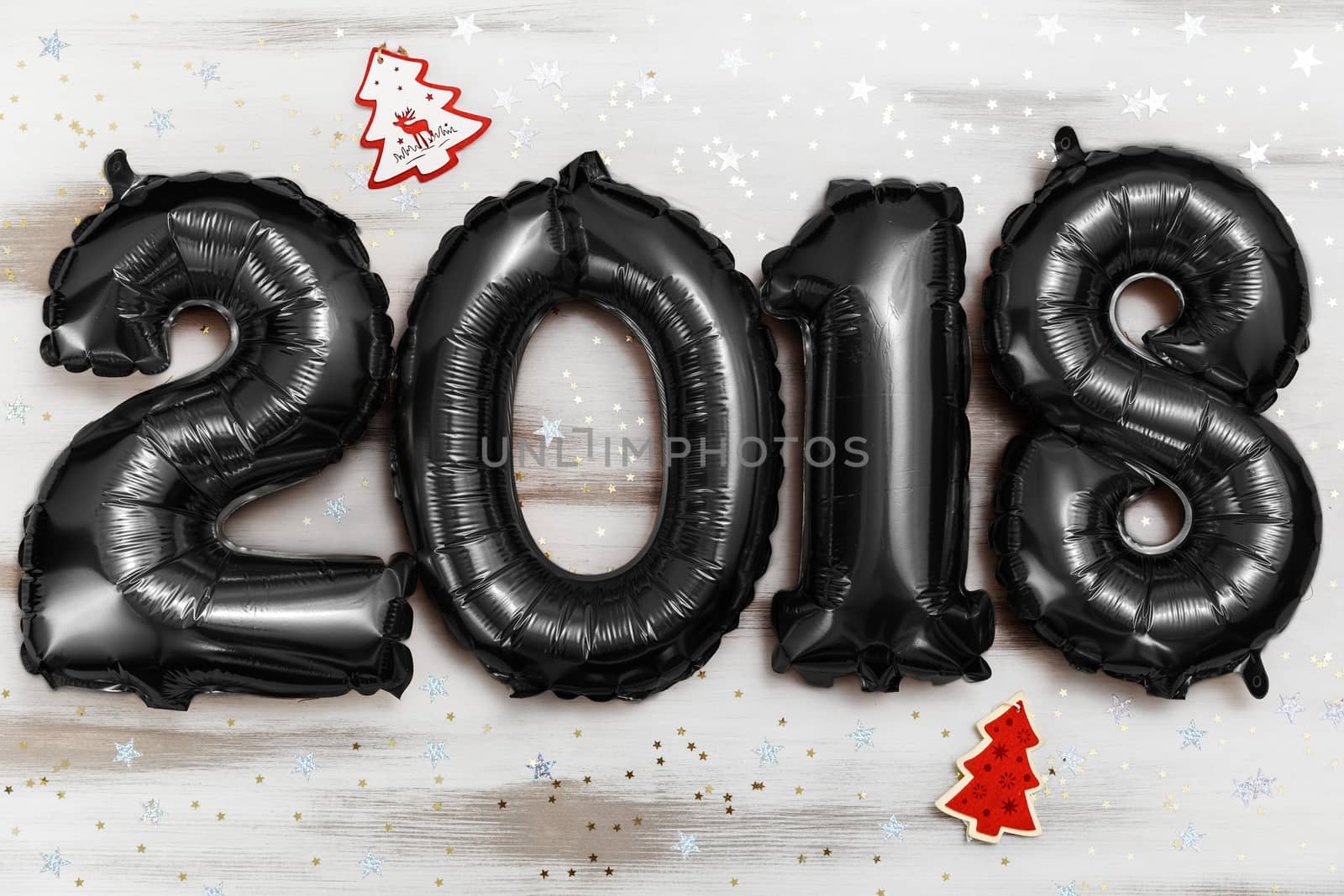 Bright black balloons figures 2018, New Year Balloons with glitter stars on white wood table background. Christmas and new year celebration