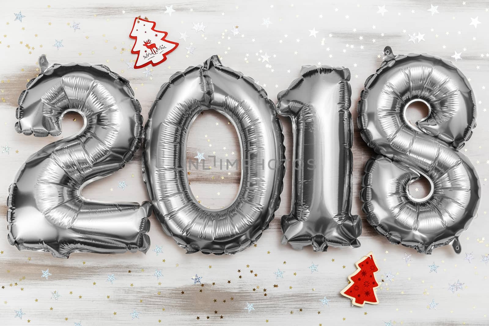 Bright silver balloons figures 2018, New Year Balloons with glitter stars on white wood table background. Christmas and new year celebration