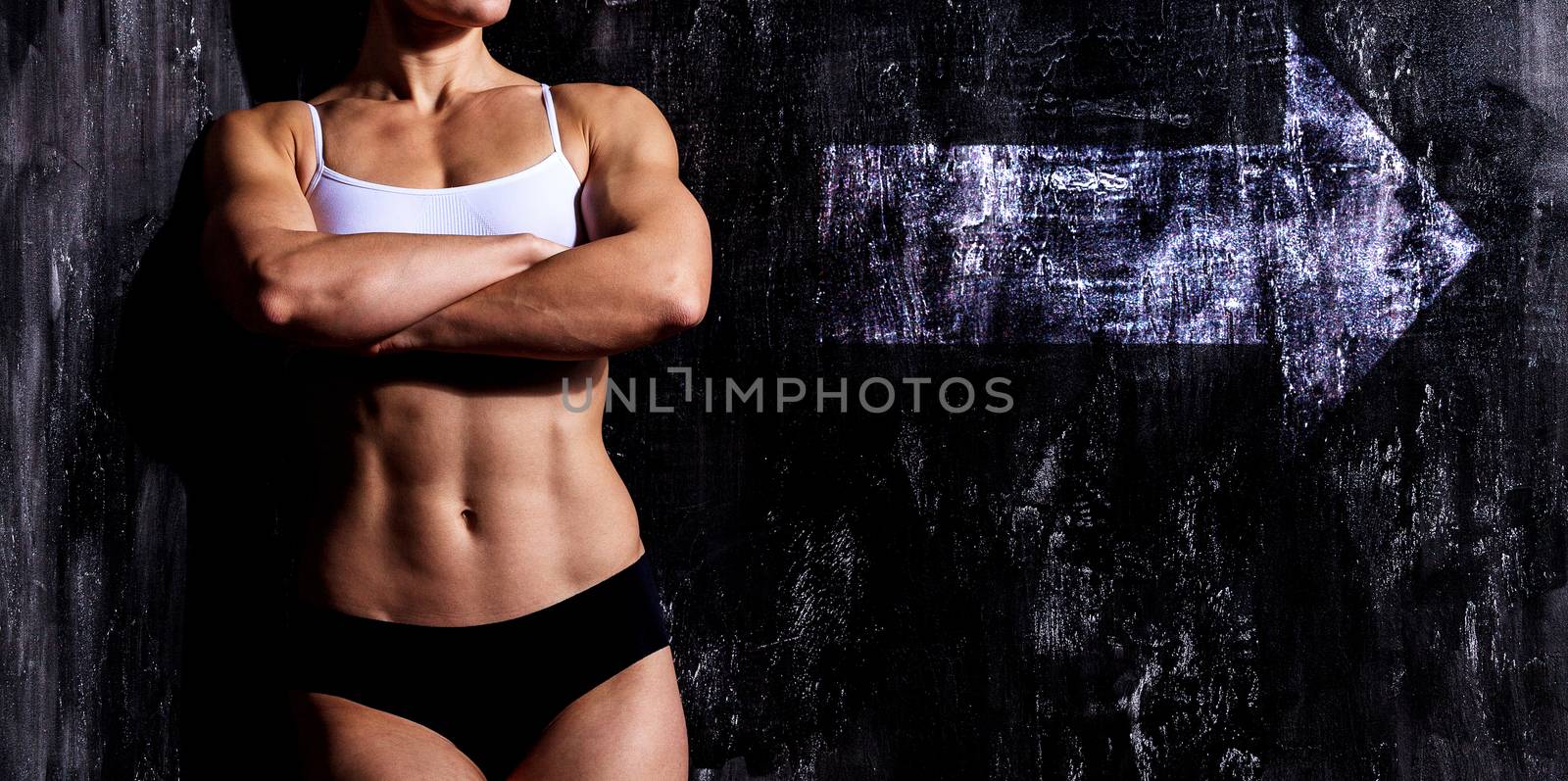 Muscular woman on a dark background with white arrow sign by Nobilior