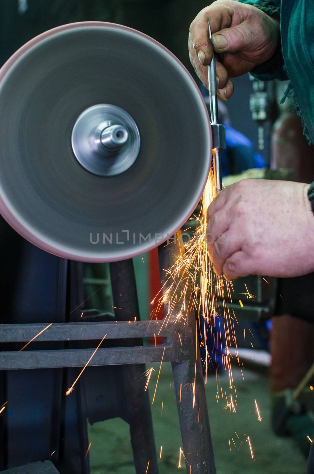 Industrial grinder showers sparks while working with metal.
