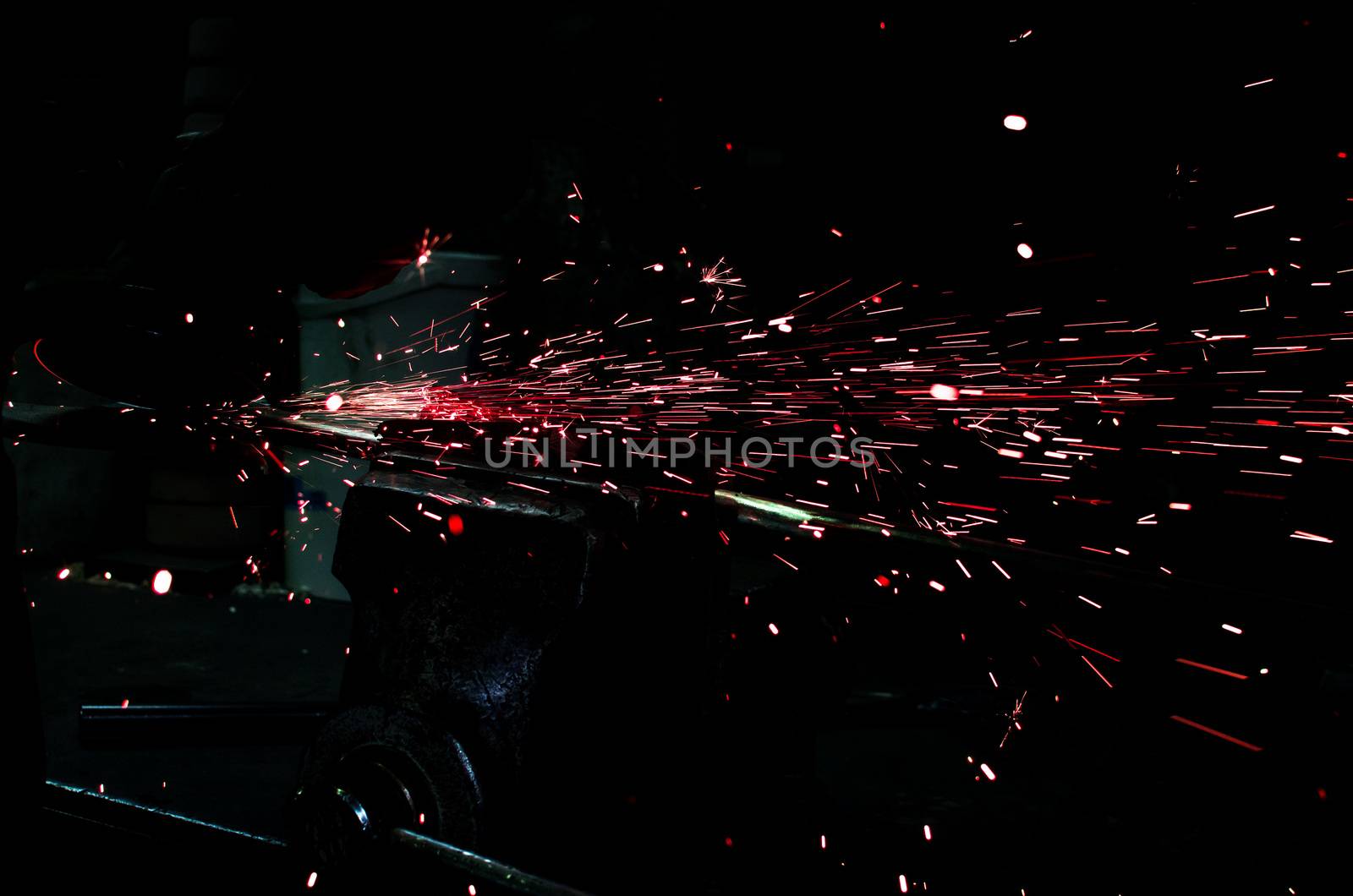 Industrial grinder showers sparks while working with metal.