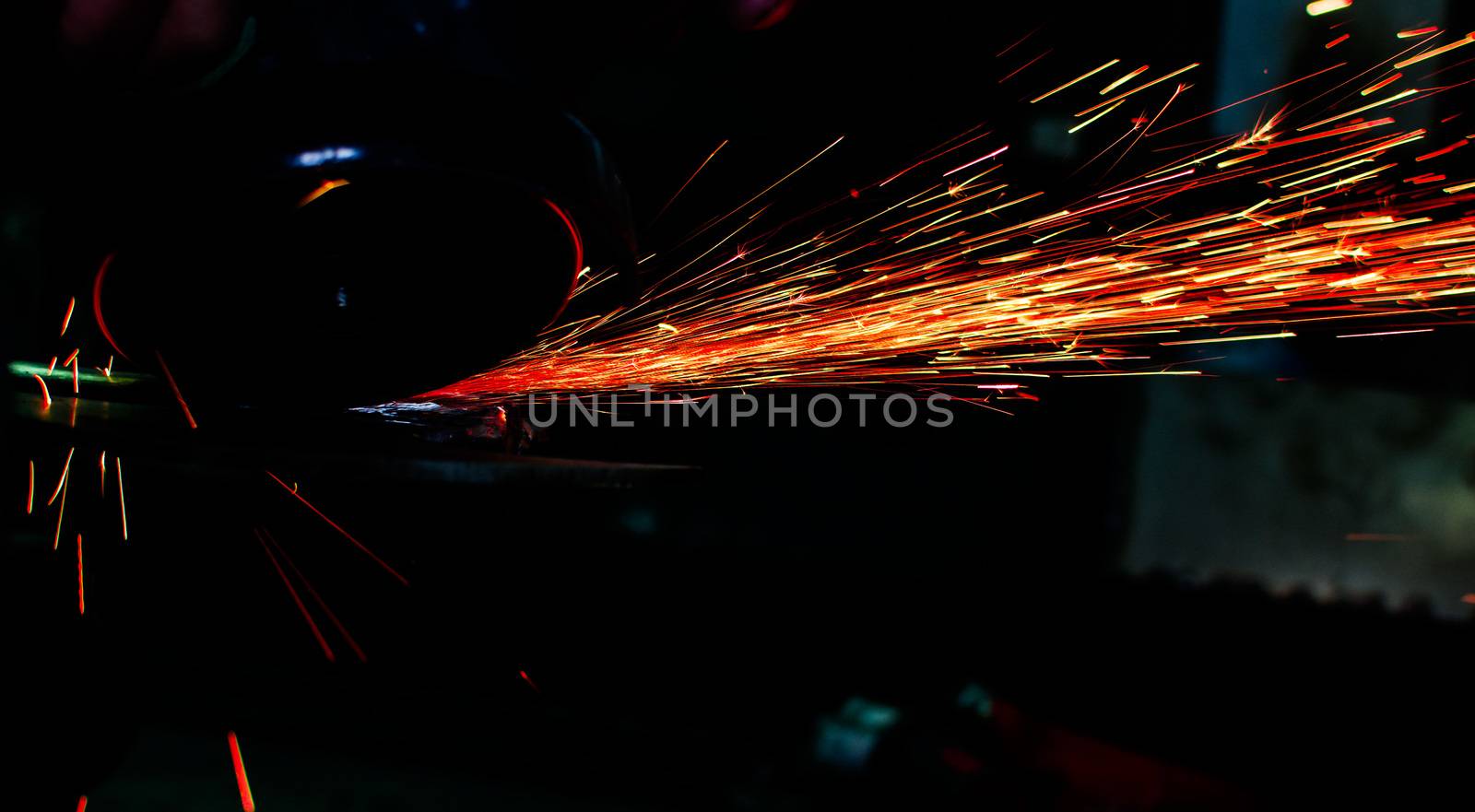 Industrial grinder showers sparks while working with metal.