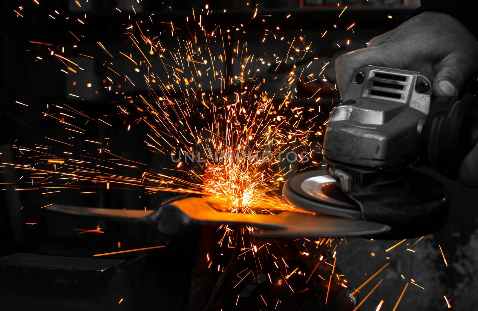 Industrial grinder showers sparks while working with metal.