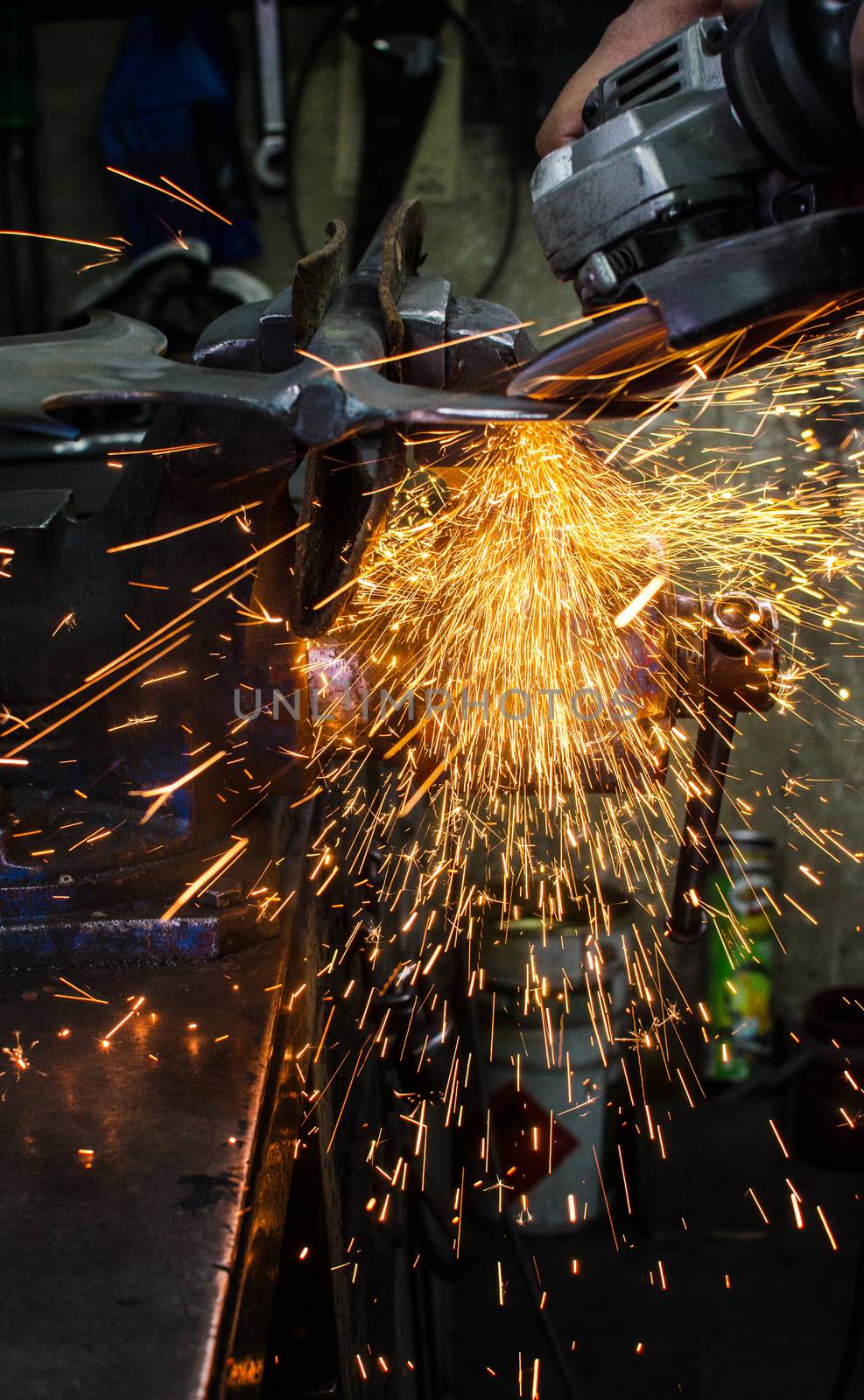 Industrial grinder showers sparks while working with metal.