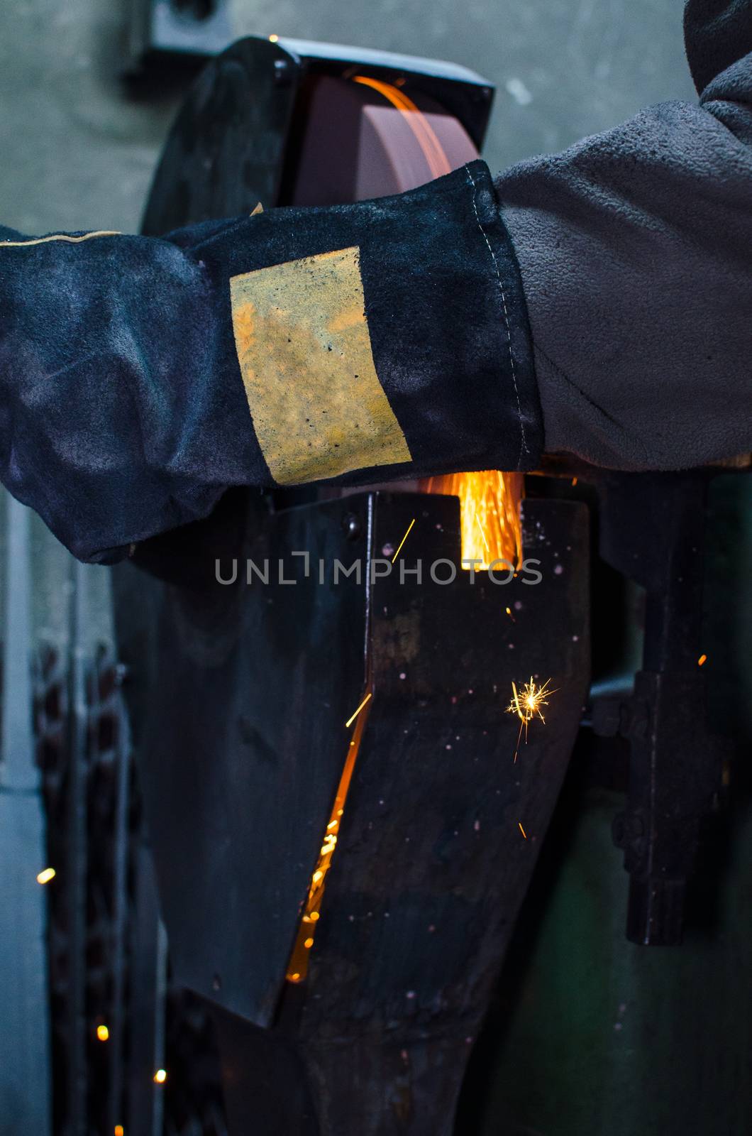 Industrial grinder showers sparks while working with metal.