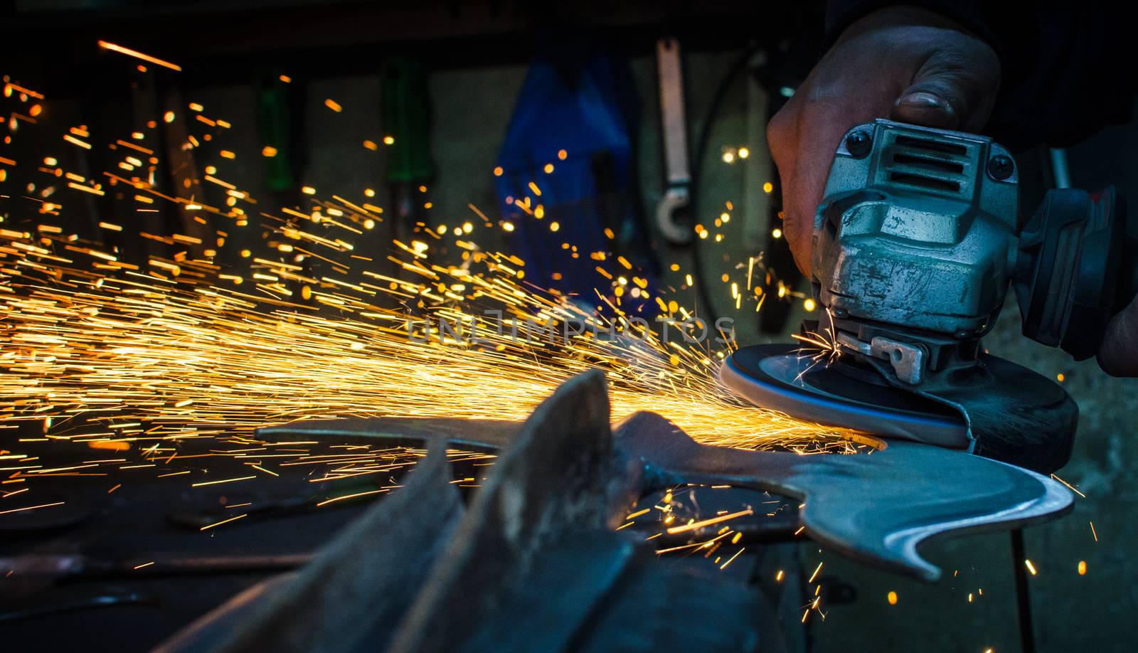 Industrial grinder showers sparks while working with metal.