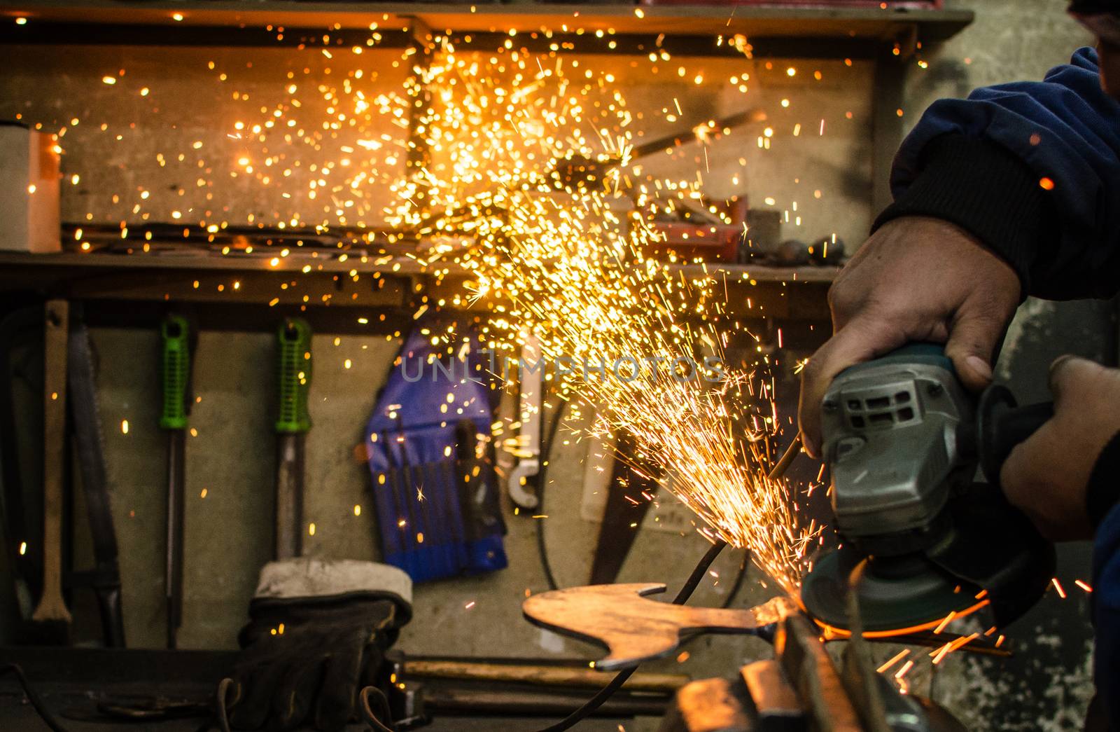 Industrial grinder showers sparks while working with metal.