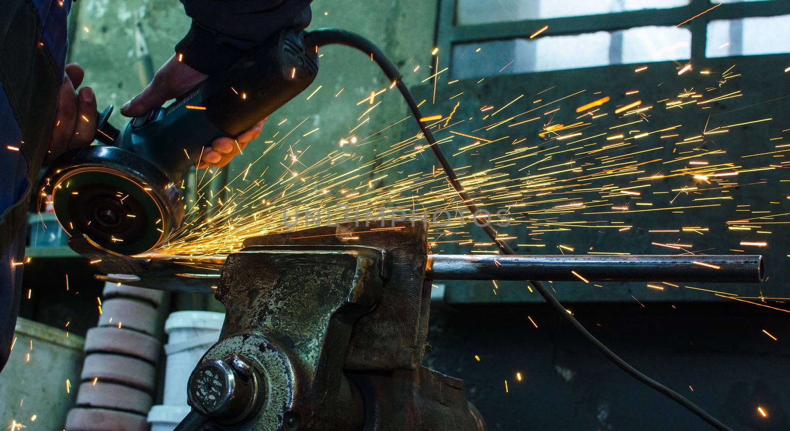 Industrial grinder showers sparks while working with metal.
